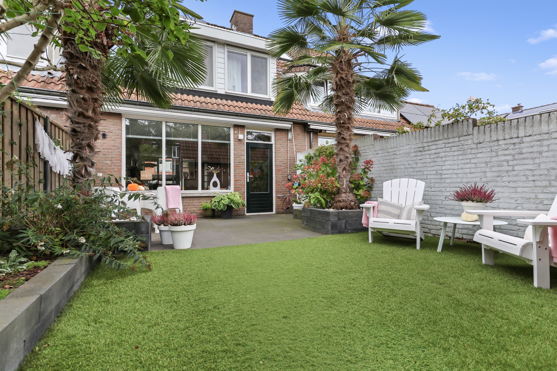 Verzorgde achtertuin met palmbomen